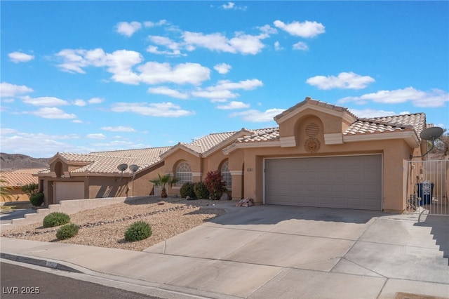 1010 Armillaria St, Henderson, NV 89011 - mediterranean / spanish-style home with stucco siding, a garage, a tiled roof, and concrete driveway