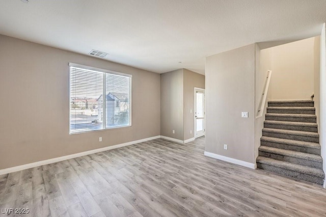 4516 Townwall St, Las Vegas, NV 89115 - unfurnished living room with light wood-style flooring, baseboards, stairs, and visible vents