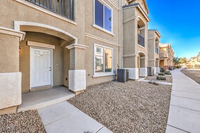 4516 Townwall St, Las Vegas, NV 89115 - entrance to property with stucco siding, central AC unit, and a residential view
