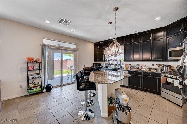 6516 Austin Hope Ave, Las Vegas, NV 89118 - kitchen featuring appliances with stainless steel finishes, a chandelier, dark stone countertops, a breakfast bar, and recessed lighting