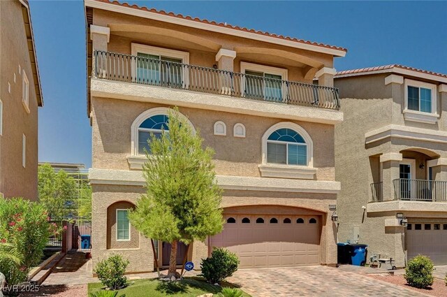 6516 Austin Hope Ave, Las Vegas, NV 89118 - mediterranean / spanish home featuring a balcony, stucco siding, a garage, and decorative driveway