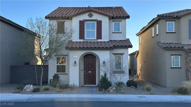 mediterranean / spanish-style house featuring stucco siding and a tiled roof