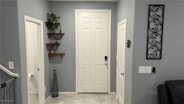 foyer featuring light tile patterned flooring and baseboards