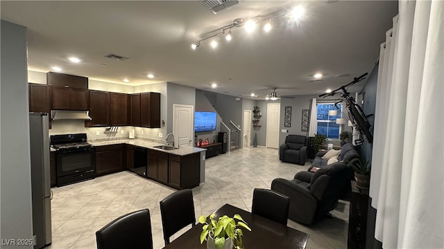 kitchen featuring open floor plan, under cabinet range hood, a sink, visible vents, and black appliances