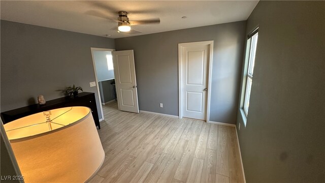 unfurnished bedroom featuring a ceiling fan, baseboards, and light wood-style floors