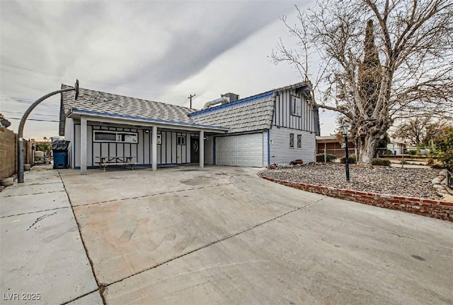 view of front of home featuring driveway, a garage, and fence