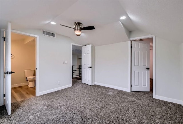 unfurnished bedroom featuring baseboards, carpet floors, visible vents, and vaulted ceiling