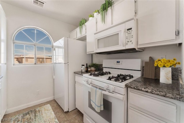 kitchen with light tile patterned flooring, white appliances, white cabinets, baseboards, and visible vents