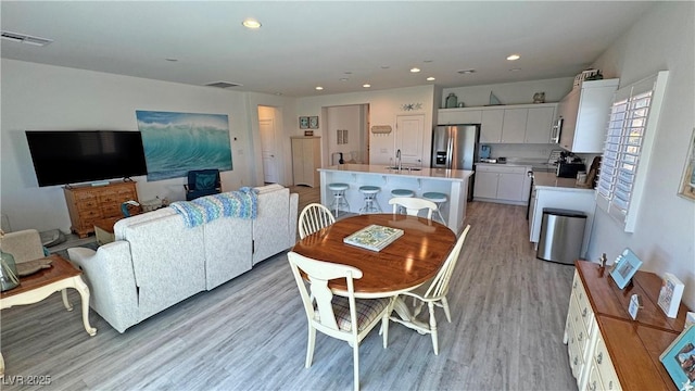 dining space with recessed lighting, light wood finished floors, and visible vents