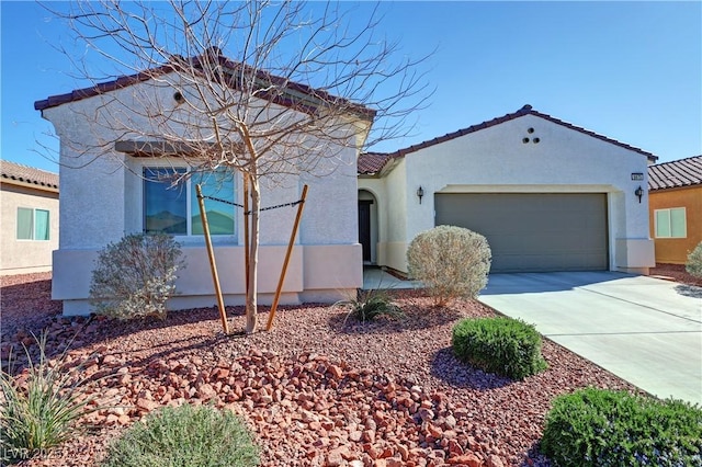 mediterranean / spanish-style house featuring driveway, stucco siding, a tile roof, and a garage