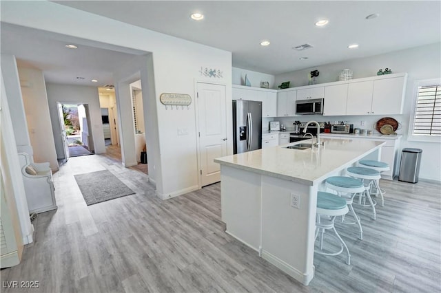 kitchen with light countertops, a sink, white cabinets, and appliances with stainless steel finishes
