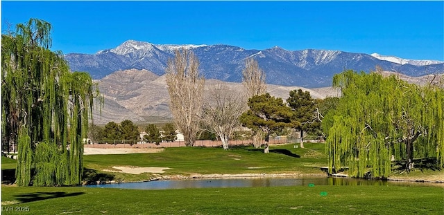 view of home's community with a water and mountain view and a lawn