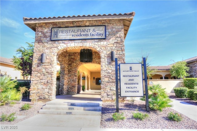 exterior space with arched walkways and stone siding