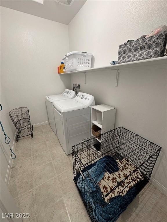 laundry room with light tile patterned flooring, washing machine and dryer, baseboards, and laundry area