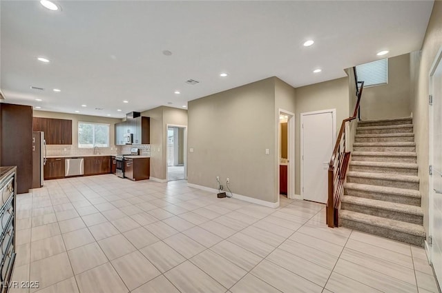 unfurnished living room with visible vents, a sink, stairway, recessed lighting, and light tile patterned flooring
