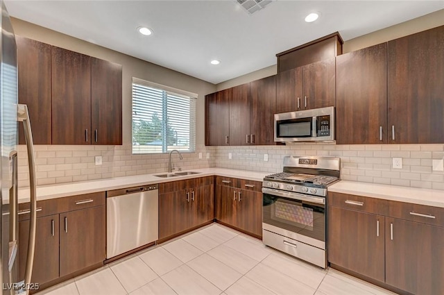 kitchen with a sink, visible vents, light countertops, and stainless steel appliances