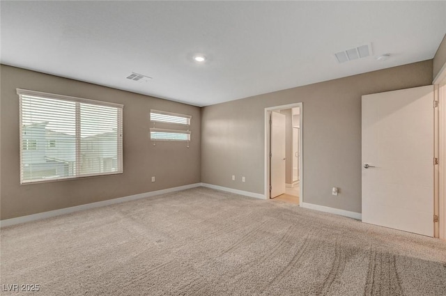 carpeted empty room featuring visible vents and baseboards