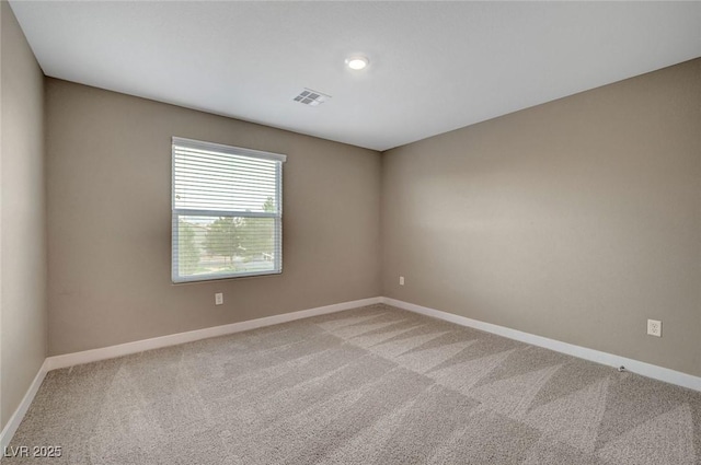 unfurnished room with light colored carpet and baseboards
