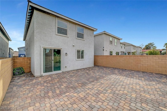 back of house featuring a patio area, a fenced backyard, and stucco siding