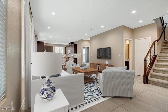 living area featuring recessed lighting, stairway, and light tile patterned flooring