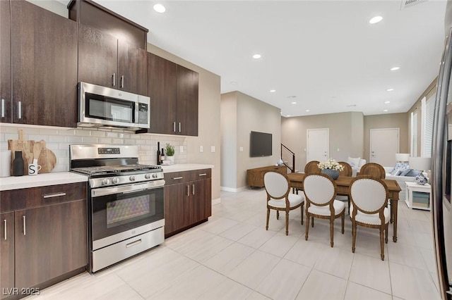 kitchen with open floor plan, light countertops, appliances with stainless steel finishes, and decorative backsplash