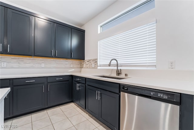 kitchen with stainless steel dishwasher, light countertops, a sink, and light tile patterned floors
