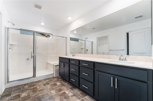 bathroom with a sink, a shower stall, and visible vents