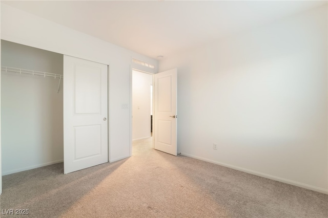 unfurnished bedroom with a closet, carpet floors, and baseboards