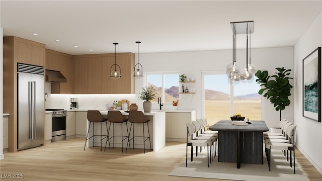dining room with light wood finished floors, recessed lighting, and a chandelier