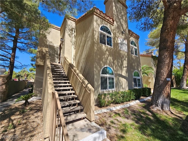 3145 E Flamingo Rd Unit 2005, Las Vegas, NV 89121 - view of side of property with stairs, stucco siding, a chimney, and a tiled roof
