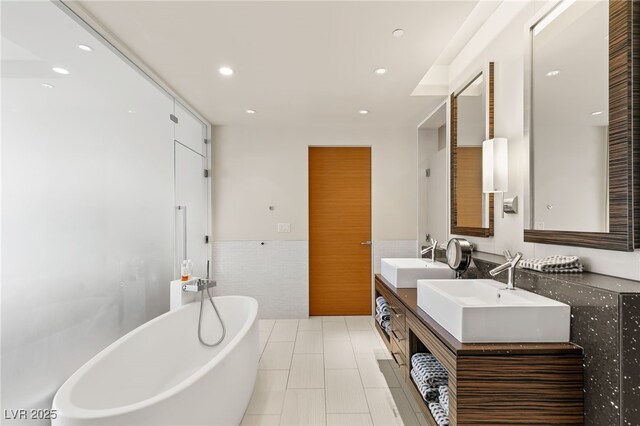 3750 Las Vegas Blvd Unit 3008, Las Vegas, NV 89158 - bathroom featuring a freestanding bath, double vanity, tile walls, recessed lighting, and a wainscoted wall
