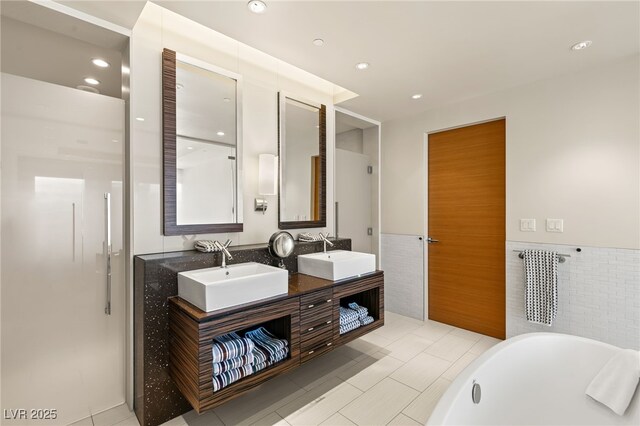 3750 Las Vegas Blvd Unit 3008, Las Vegas, NV 89158 - full bath with a freestanding bath, double vanity, tile walls, wainscoting, and recessed lighting