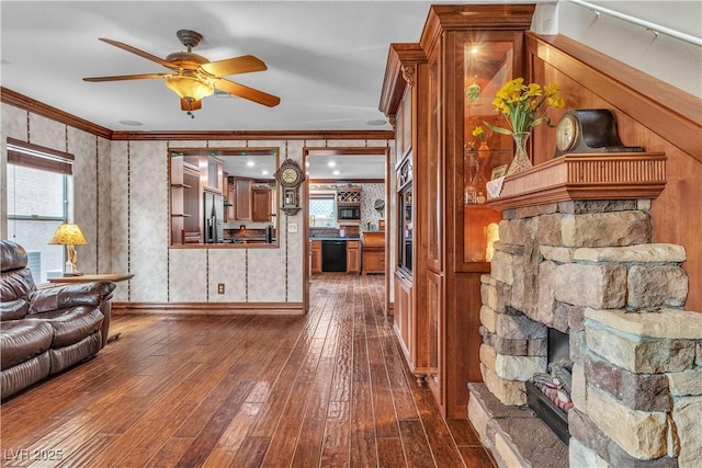 5050 Secret Rock St, Las Vegas, NV 89122 - living area featuring crown molding, a ceiling fan, dark wood-style flooring, and a stone fireplace