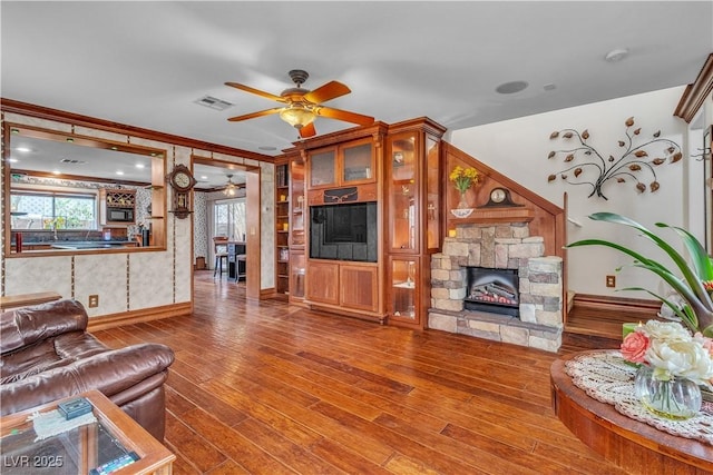 5050 Secret Rock St, Las Vegas, NV 89122 - living area featuring ceiling fan, wood finished floors, a fireplace, and crown molding
