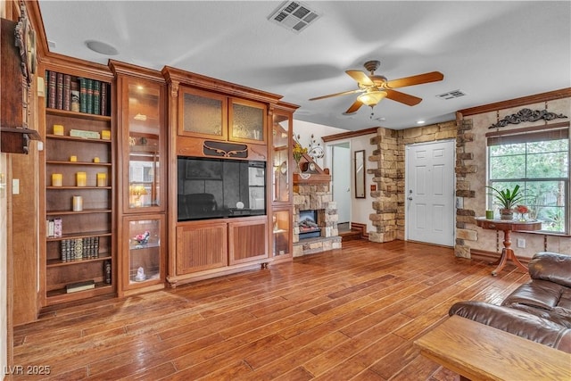 5050 Secret Rock St, Las Vegas, NV 89122 - living room featuring ceiling fan, a fireplace, and wood finished floors