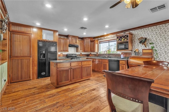 5050 Secret Rock St, Las Vegas, NV 89122 - kitchen featuring black appliances, light wood-type flooring, under cabinet range hood, ornamental molding, and wallpapered walls