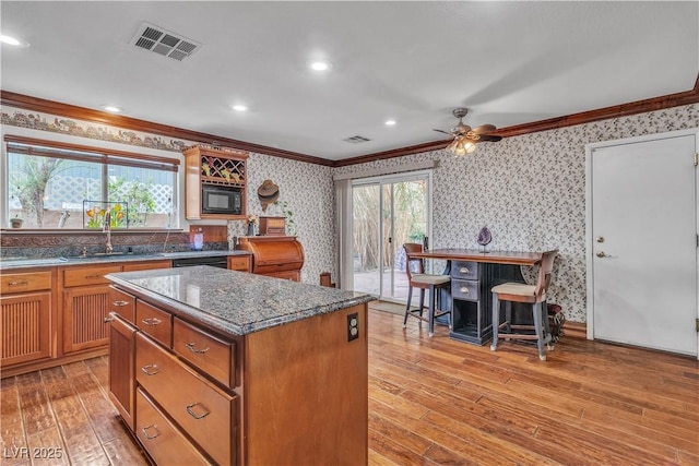 5050 Secret Rock St, Las Vegas, NV 89122 - kitchen with ornamental molding, wallpapered walls, light wood finished floors, a ceiling fan, and a center island