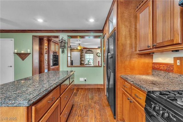 5050 Secret Rock St, Las Vegas, NV 89122 - kitchen featuring dark wood-type flooring, ornamental molding, brown cabinets, a ceiling fan, and black appliances