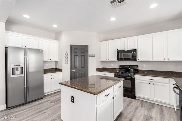 kitchen with white cabinets, black appliances, light wood-style flooring, and visible vents