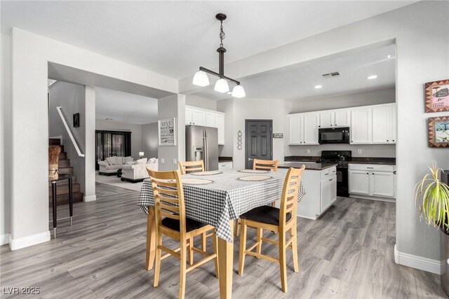 dining area featuring visible vents, light wood-type flooring, stairway, baseboards, and recessed lighting