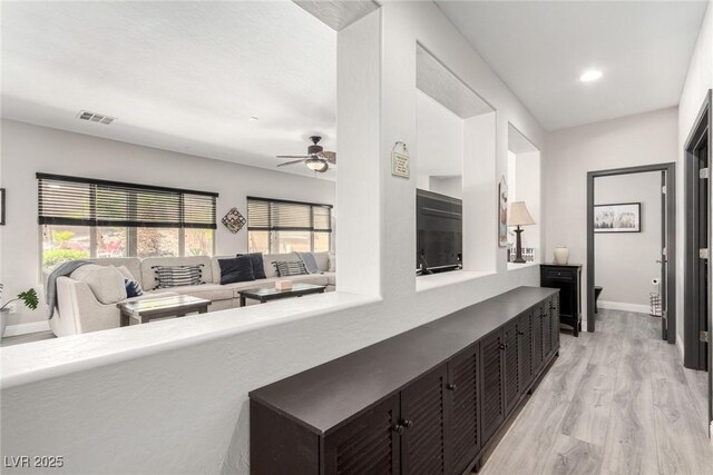 corridor with light wood-style floors, baseboards, recessed lighting, and visible vents