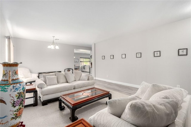 living area featuring baseboards and a chandelier