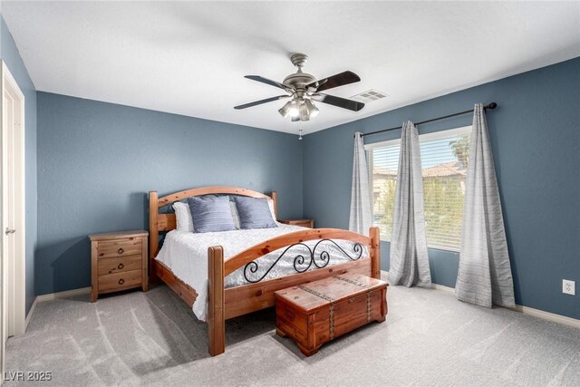 carpeted bedroom with baseboards, a ceiling fan, and visible vents