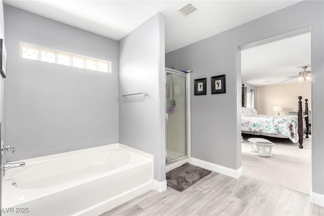full bath featuring a garden tub, visible vents, wood finished floors, connected bathroom, and a shower stall