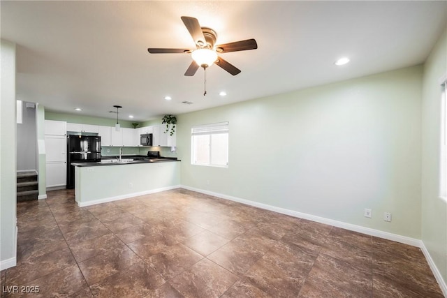 7649 Calico Fields St, Las Vegas, NV 89149 - kitchen with a sink, dark countertops, a ceiling fan, a peninsula, and black appliances