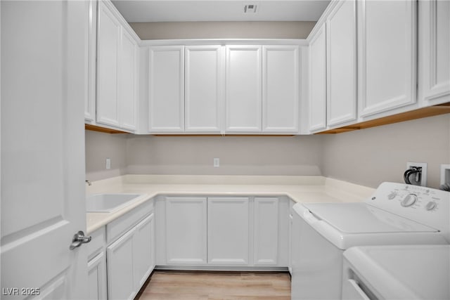665 Look Lively Ct, Henderson, NV 89011 - clothes washing area with cabinet space, washing machine and dryer, and light wood finished floors