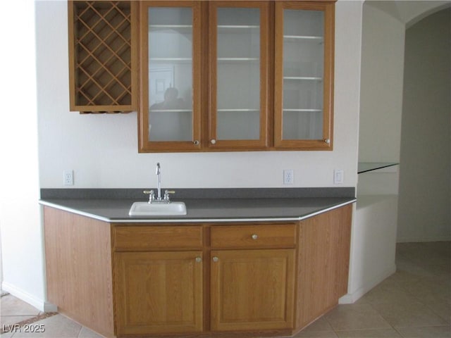 10112 Plomosa Pl, Las Vegas, NV 89134 - bar area with a sink, arched walkways, light tile patterned floors, and baseboards