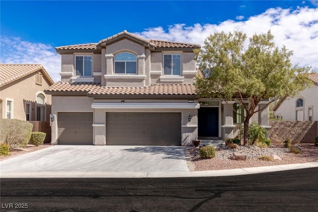mediterranean / spanish-style house with stucco siding, driveway, a garage, and a tiled roof