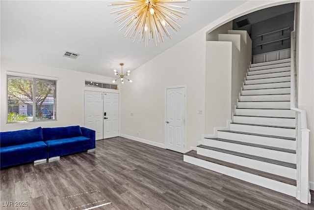 entryway featuring an inviting chandelier, wood finished floors, stairway, and visible vents