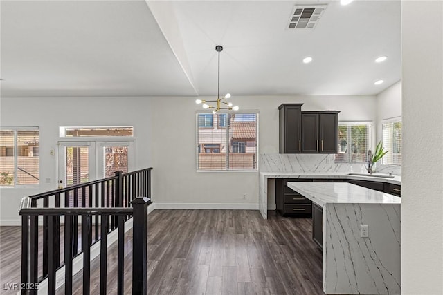kitchen with baseboards, a chandelier, a sink, dark wood-style floors, and visible vents